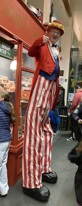 Man dressed as a clown on stilts