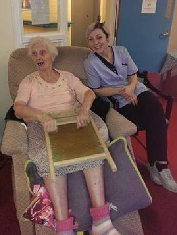 One of the residents showing the young carers how to use a washboard